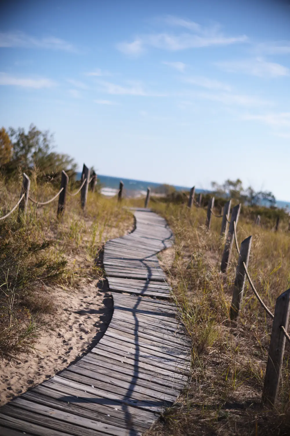 A wooden boardwalk winding through dune grass toward Lake Michigan at Kohler-Andrea State Park, Wisconsin